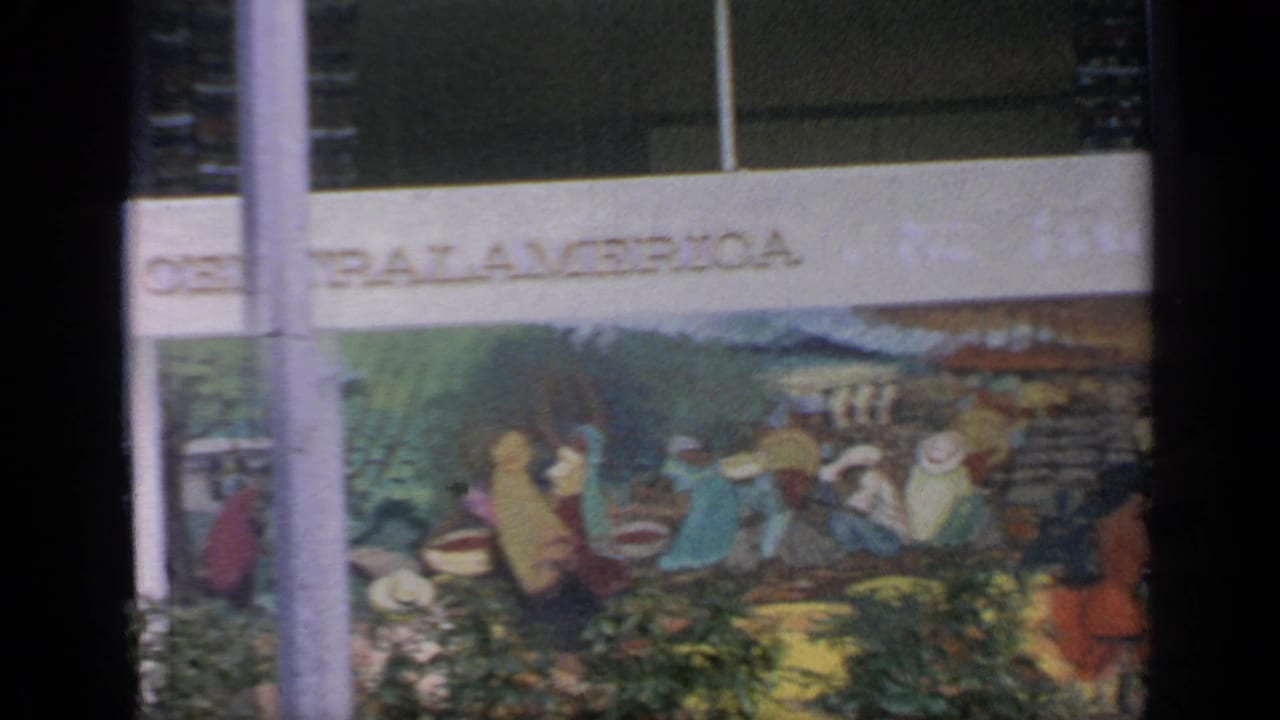 Central America mural on an exterior pavilion wall with trees and vertical posts in front.