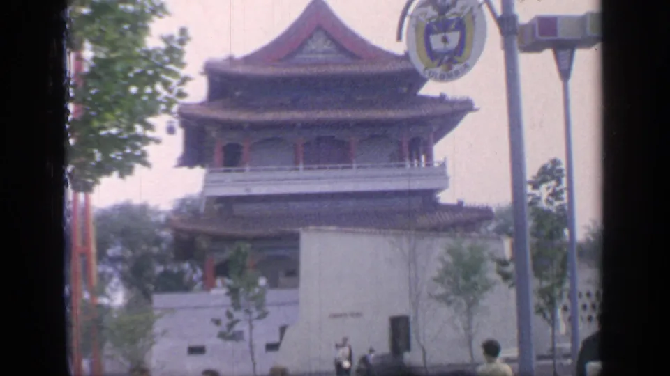 1964 Flushing Meadows view of a Chinese-style pagoda with red roof trim, white walls, fairground signposts, trees, and visitors below.