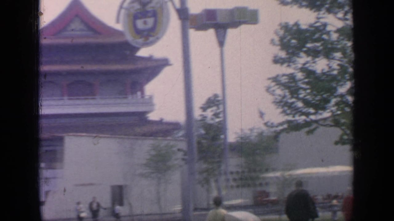 Visitors pass a Chinese-themed pavilion structure at a fairground.