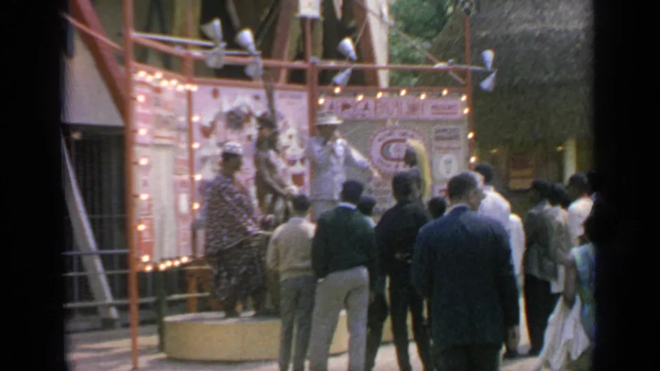 Visitors at the 1964 Flushing Meadows fair gather near a lit Chinese cultural display and performers.