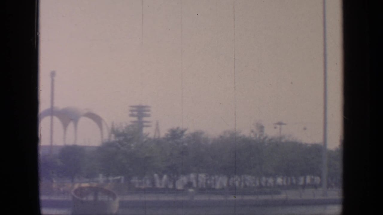 Fairground arches and trees viewed through a soft, faded frame.