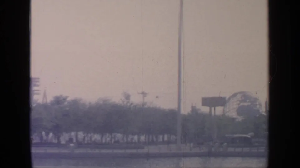 Flushing Meadows fairground scene with trees, a roadside view, and a distant spherical structure consistent with World's Fair architecture.