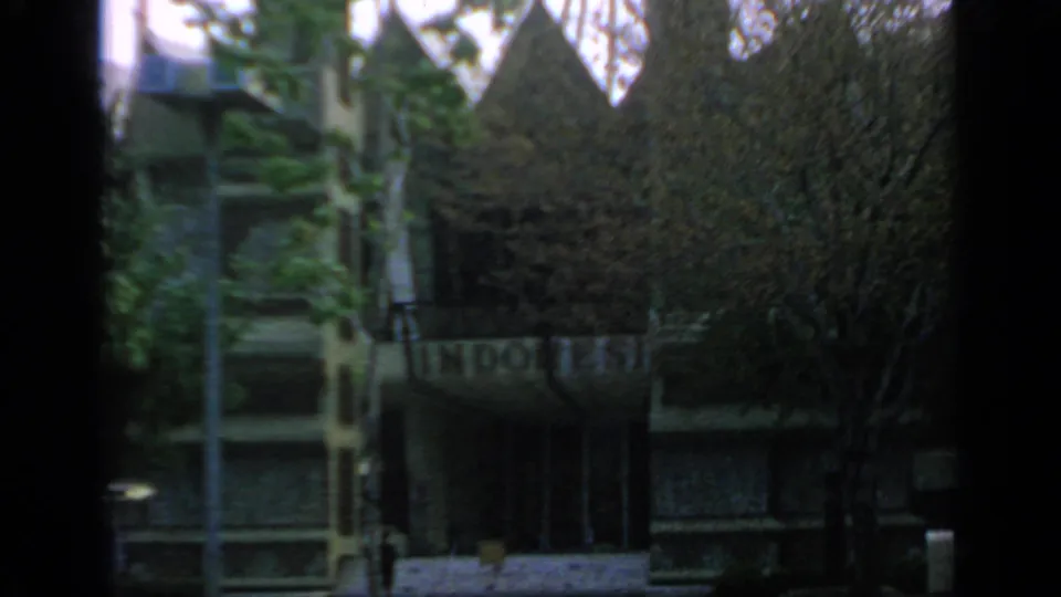 Shaded 1964 Flushing Meadows fairground structure with trees, vertical railings, stairs, and partially legible signage.