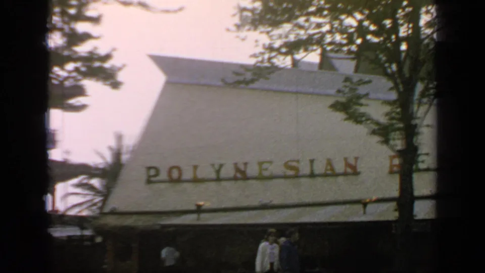 The final frame holds on the Polynesian Restaurant roof sign, tree branches, and a few visitors at the World's Fair site.