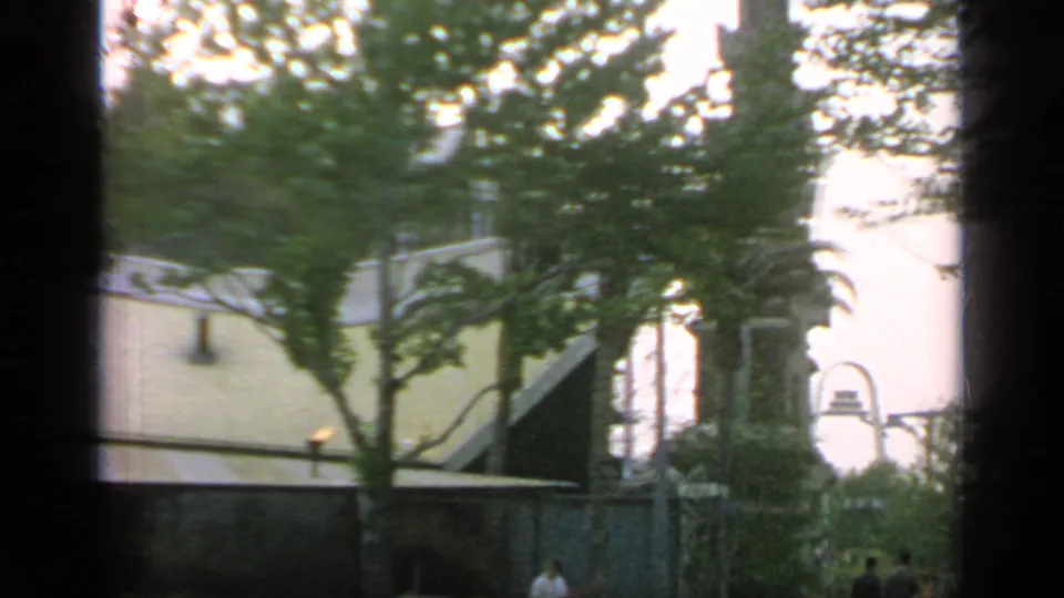 The final frame shows trees and the restaurant wall giving way to a distant arched structure at Flushing Meadows.