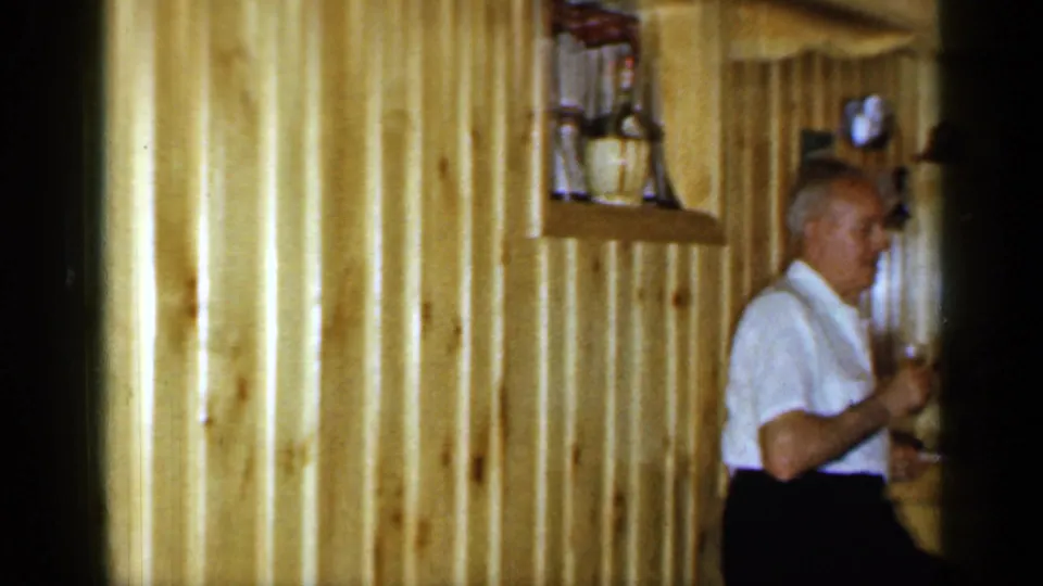 A brief 1965 tavern frame shows an older man near wood paneling and bar fixtures inside the Long Island location.