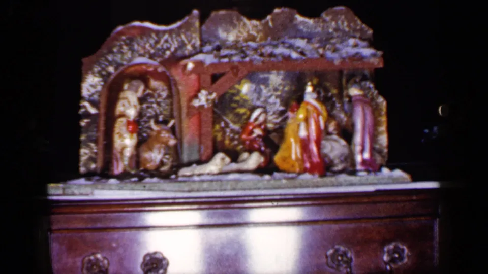 Color 8mm frame from the 1965 Long Island clip showing the nativity arrangement, chest drawers, and soft film grain.