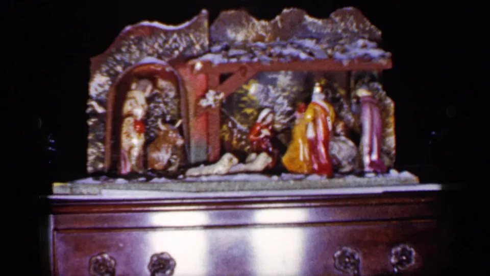 Final 1965 Long Island frame showing the Christmas nativity scene on a chest, with soft exposure and 8mm color texture.