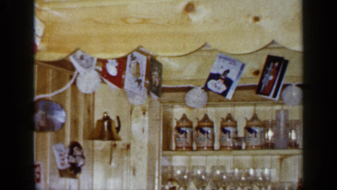 Pine-paneled shelving with hanging cards, steins, glassware, and a small bell.