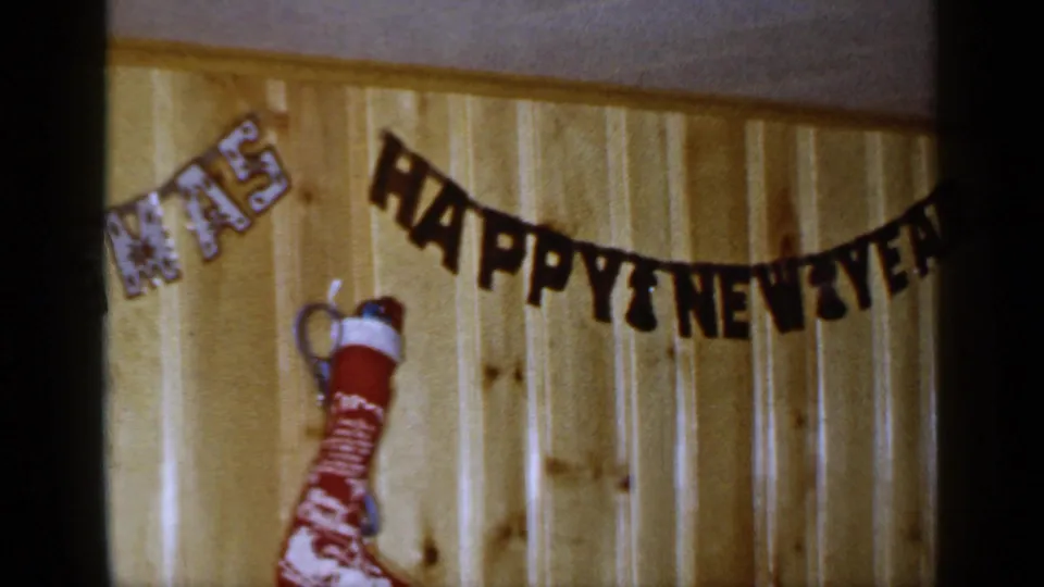 1965 Long Island holiday room detail showing a black HAPPY NEW YEAR banner, partial CHRISTMAS lettering, and a red stocking.