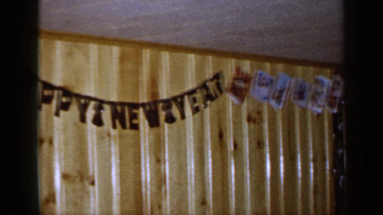 Happy New Year banner and holiday cards on a wood-paneled wall.