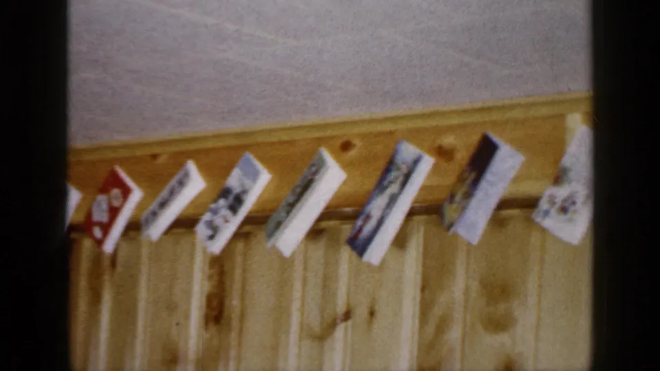 A closer view shows Christmas cards clipped or strung along the upper wood-paneled wall of the Long Island holiday interior.