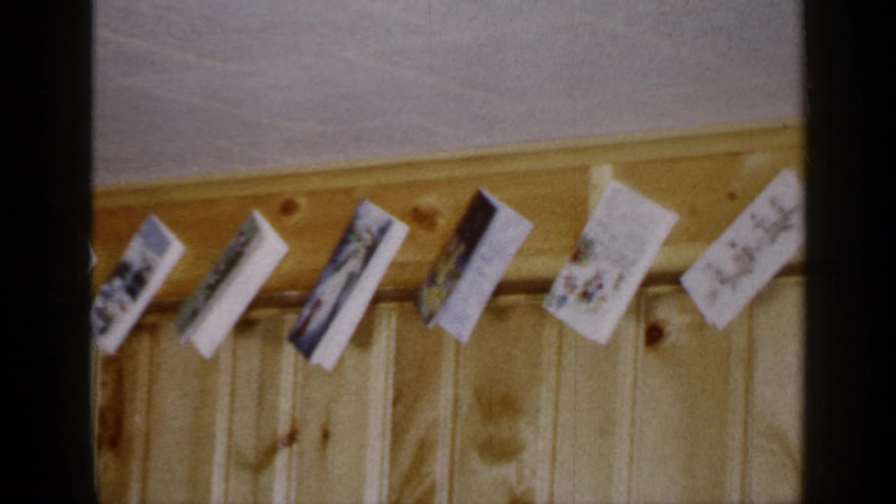 Religious greeting cards clipped along a wooden paneled wall.