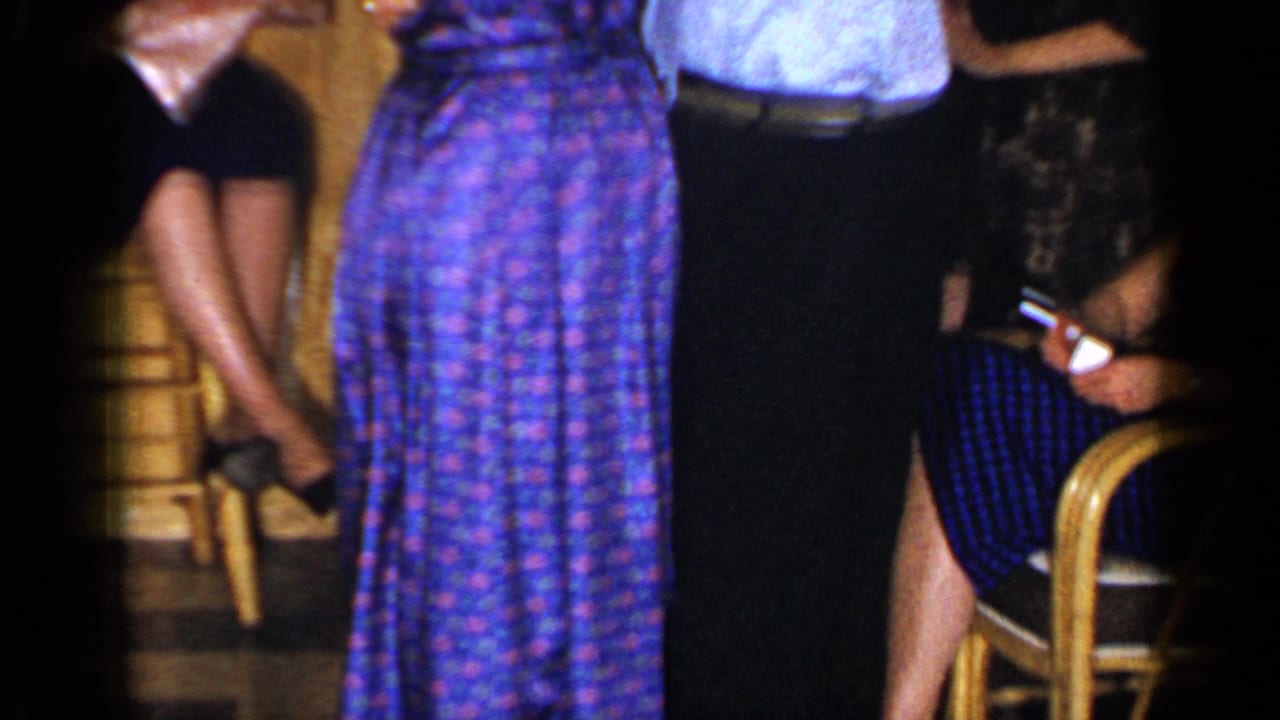 Adults dancing and seated guests in a warm wood-paneled room.