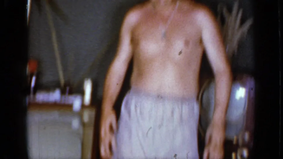 The man dances in underwear in the Mineola home interior, framed softly by the handheld 8mm camera.