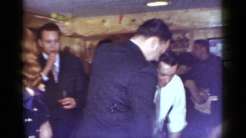 A crowded 1966 Mineola bar gathering shows adults dancing and socializing near wood paneling and a bar area.
