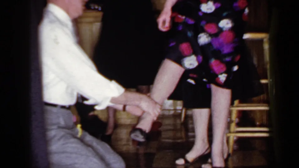 The Mineola 1966 party-game footage shows the blindfolded man touching a woman's lower leg beside indoor chairs.