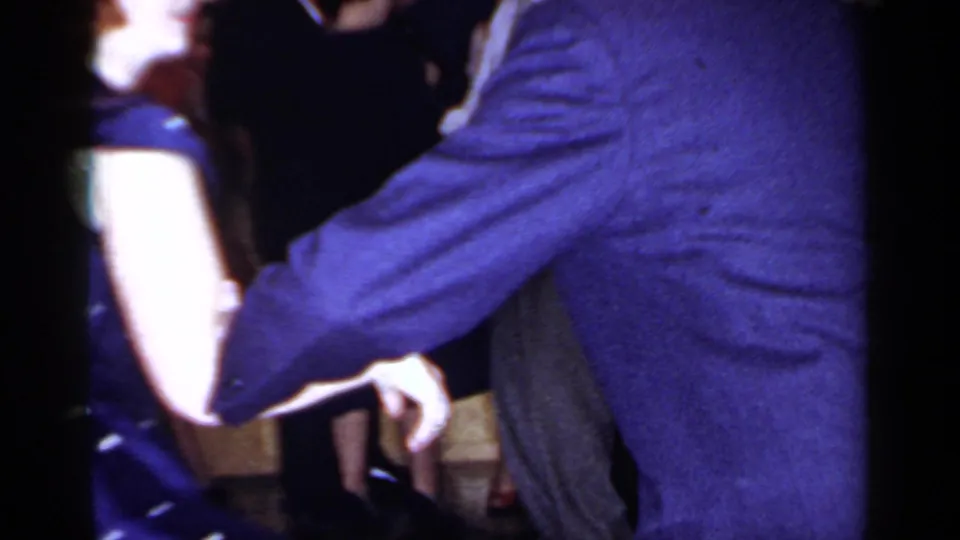 1966 Mineola party frame with a close view of adults dancing or passing through a crowded interior.