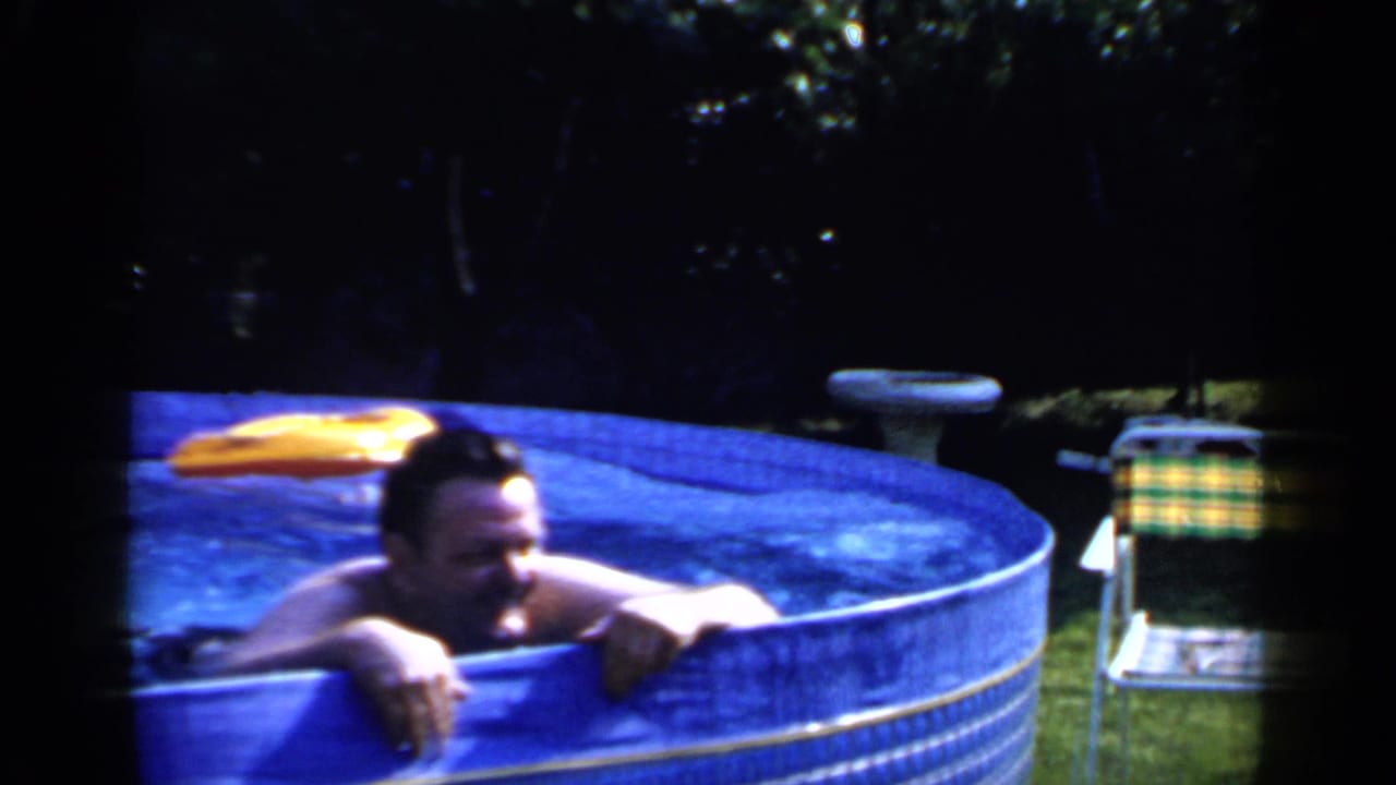 Man leaning on the edge of a blue above-ground pool with a yellow inflatable nearby.