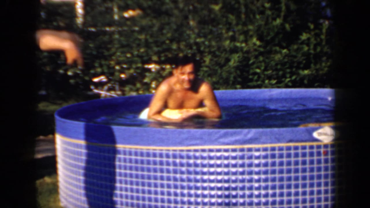 Adult man relaxes in a blue above-ground pool on a yellow float.