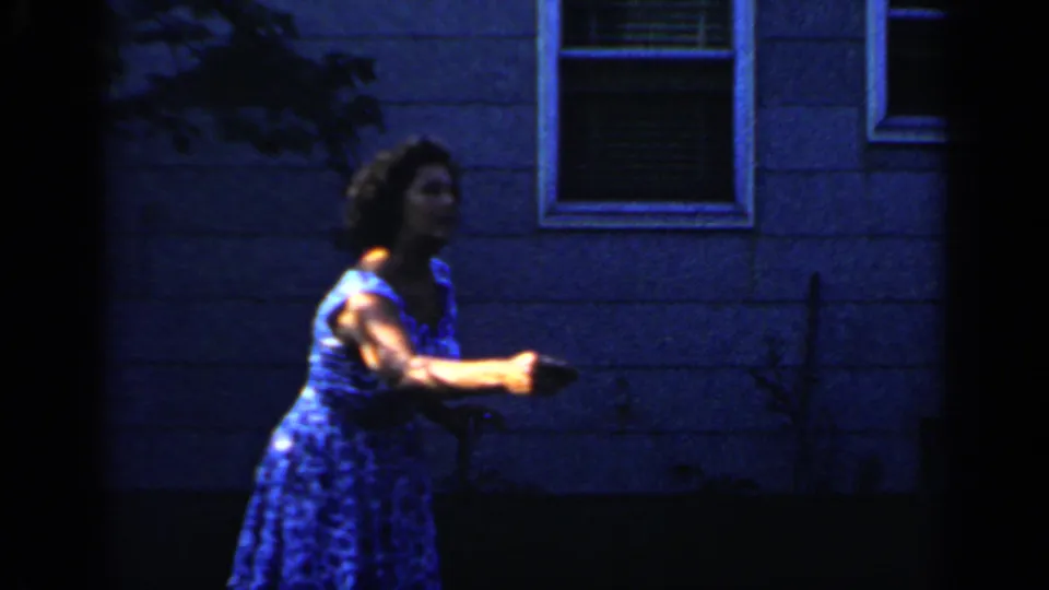 1966 Mineola frame with a woman gesturing outside a blue-sided house, while the backyard pool remains visible above.