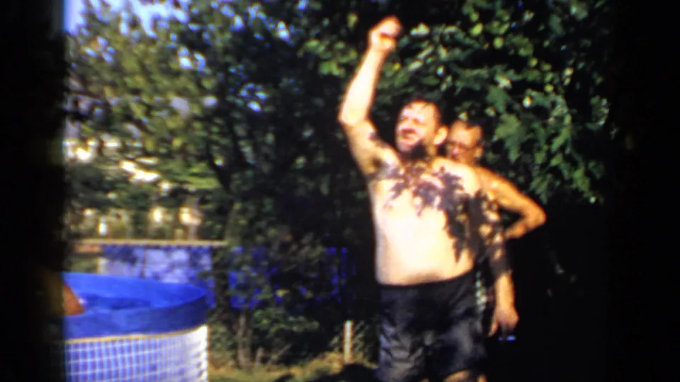 In the Mineola backyard scene, one man raises his arm near the pool while another man is partly visible behind him.