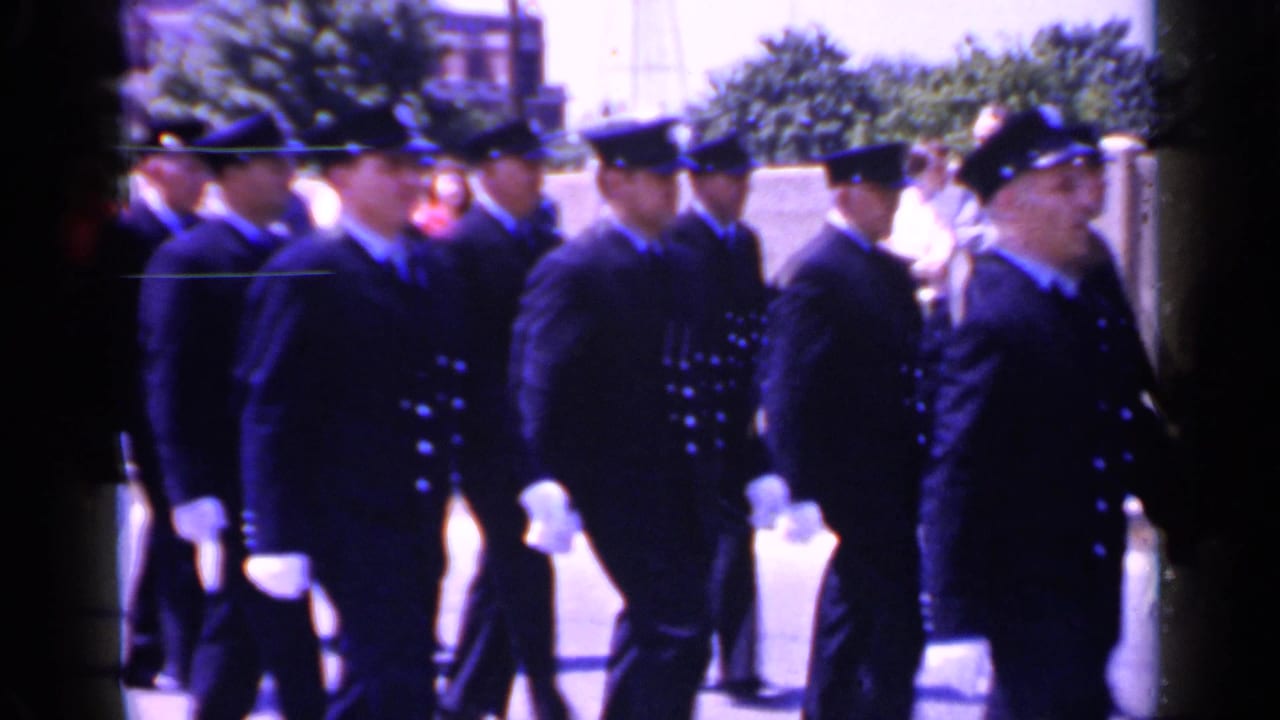 Cadets in dark uniforms pass close to the camera.