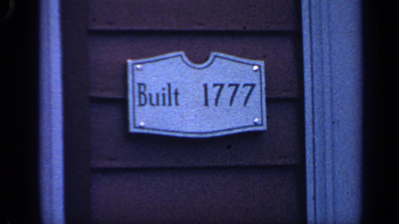 Metal plaque reading Built 1777 mounted on dark wooden siding.