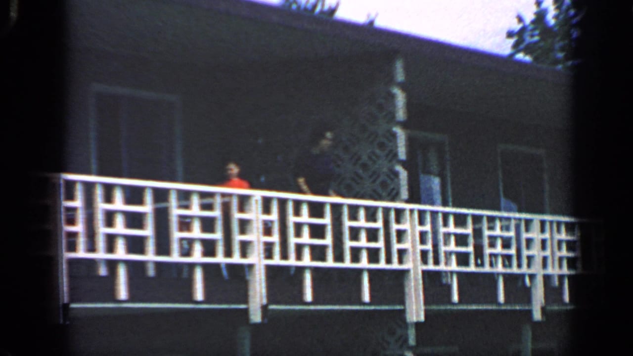 White-railed balcony on a dark building with small figures near the walkway.