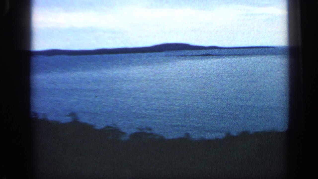 Wide blue water with a low island-like horizon and dark frame borders.