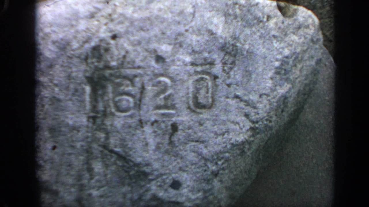 Weathered stone marker with carved 1620 numerals in close-up.