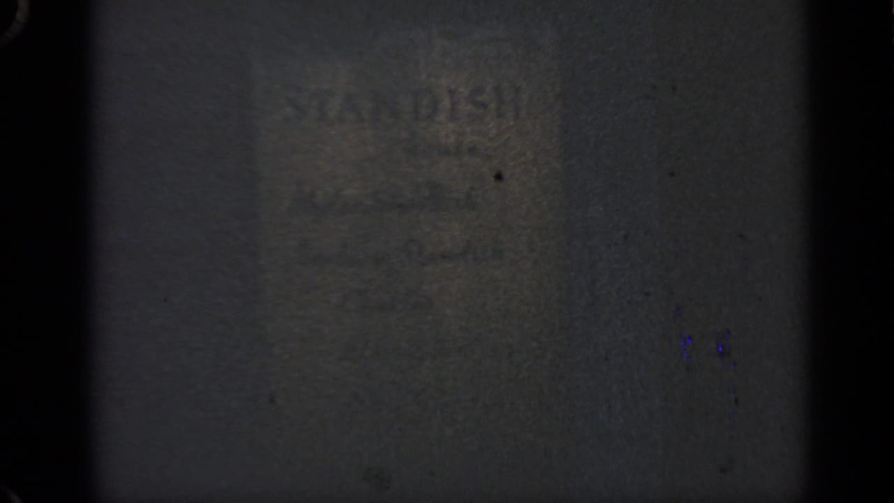 Faint STANDISH lettering on a dark textured wall surface.
