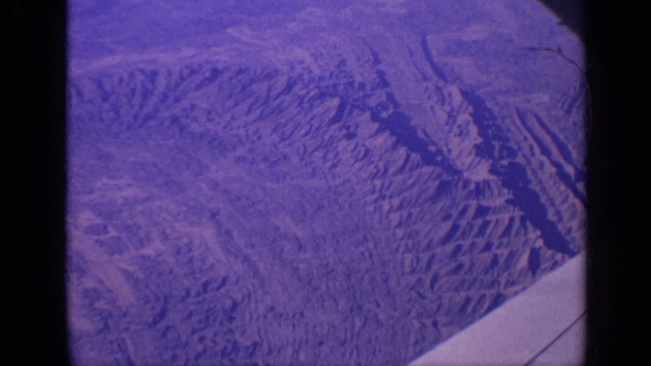 Purple-blue terrain-like surface seen within rounded 8mm film borders.