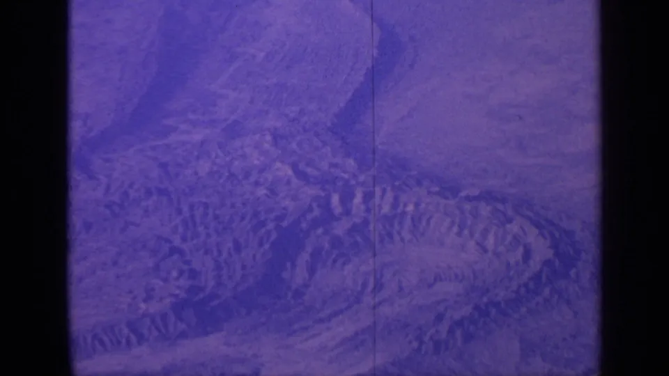 1970 India 8mm frame showing a purple-shift aerial view of rugged circular terrain and concentric ridges.