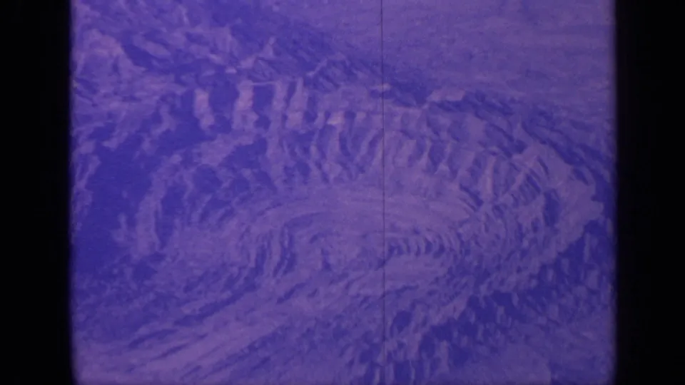 1970 India 8mm frame with circular rocky patterns, purple film cast, and a dark vertical frame division.