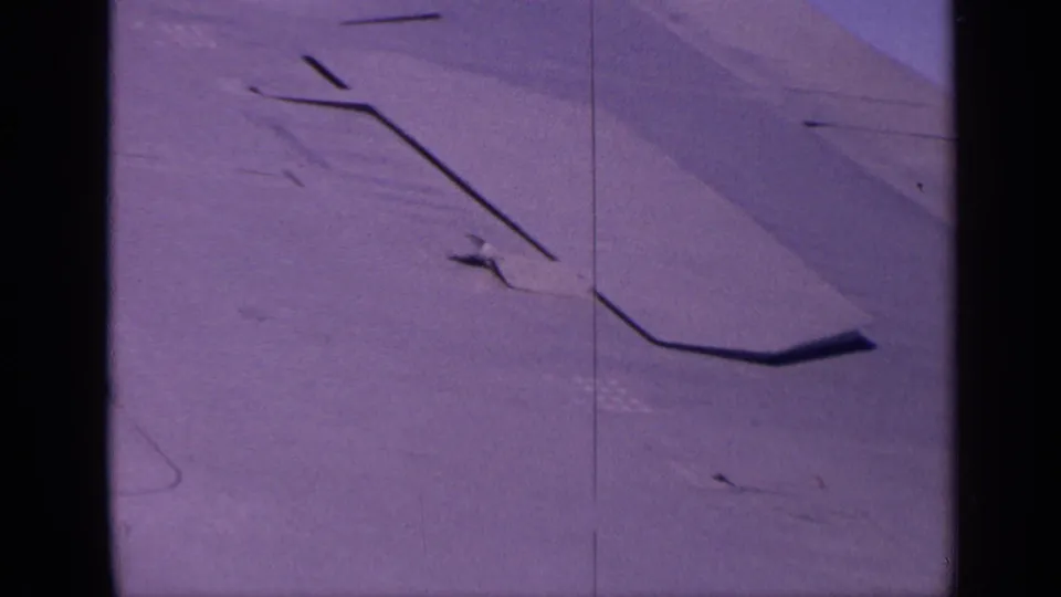 1970 India home-movie frame focused on the aircraft wing surface, panel lines, and aged 8mm texture.