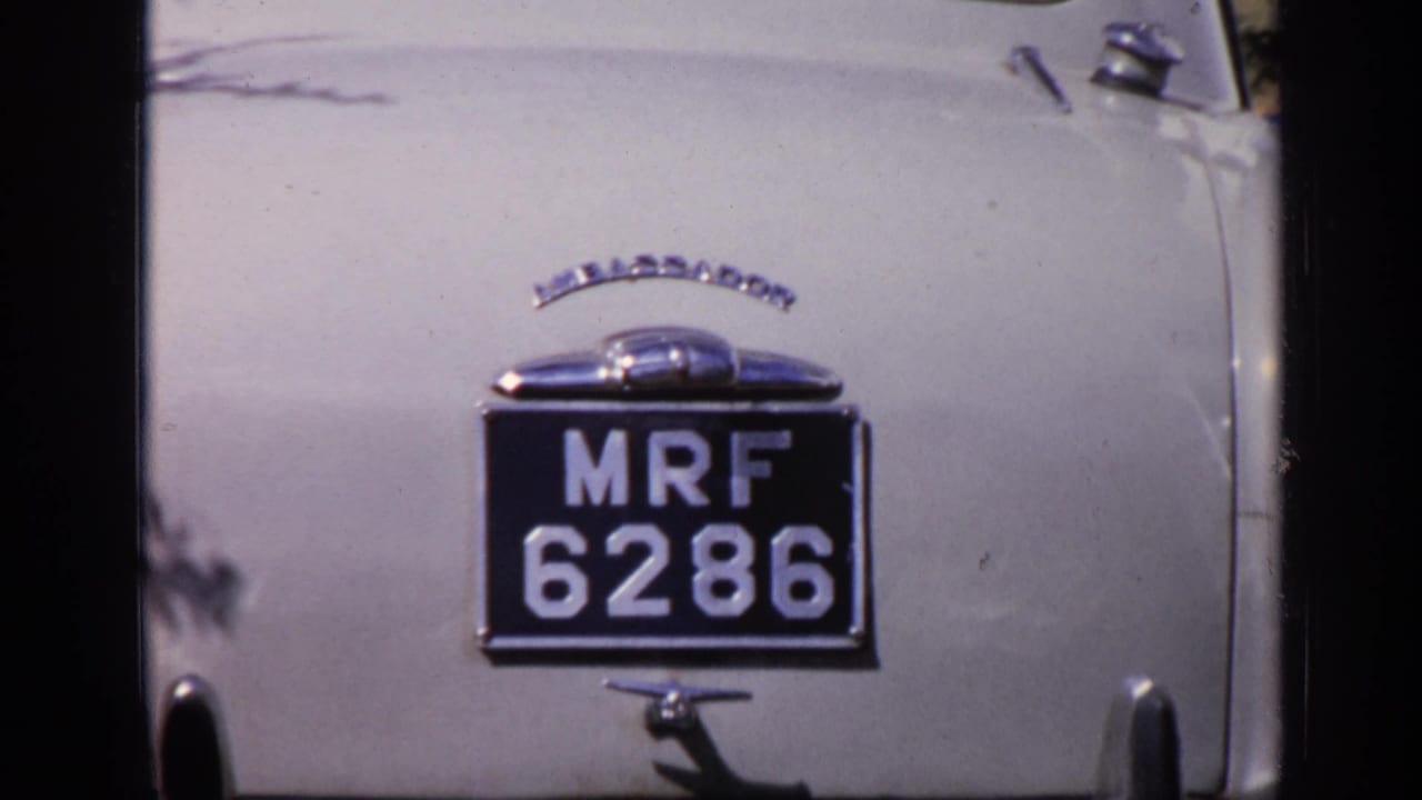 Close rear detail of a white Ambassador car in India, with chrome trim and black license plate reading MRF 6286.