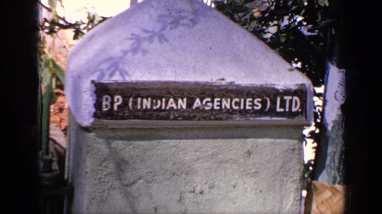 Concrete pillar with a BP Indian Agencies Ltd. sign under foliage.
