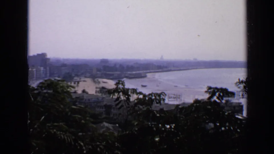 A second 1970 India coastal view shows the sea curving along the shore, with buildings and trees partly framing the scene.