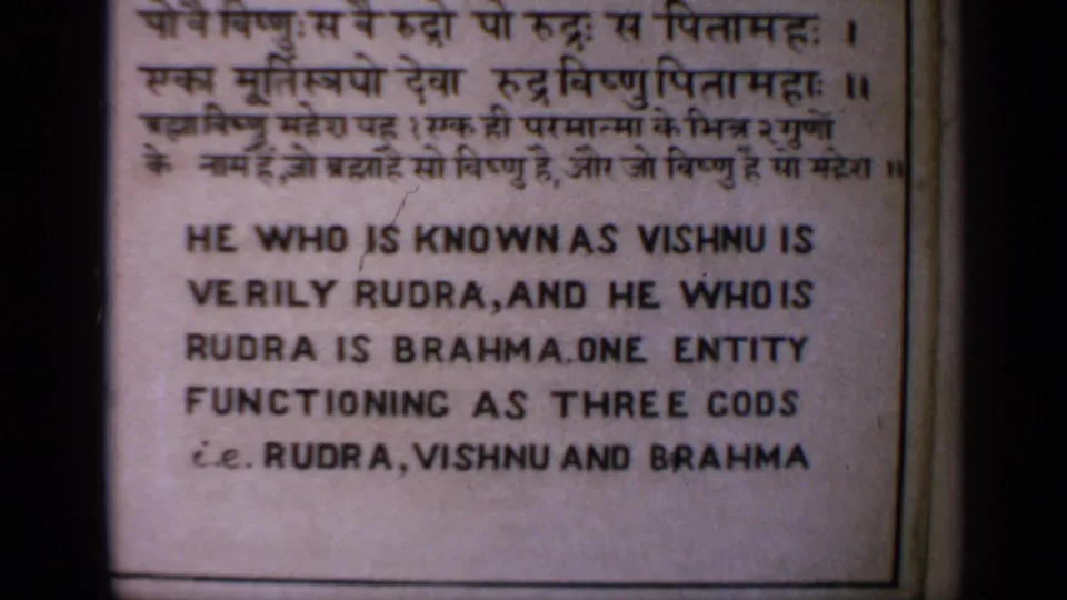 1970 India 8mm frame showing a close-up of a religious sign about the Hindu trinity of Rudra, Vishnu, and Brahma.