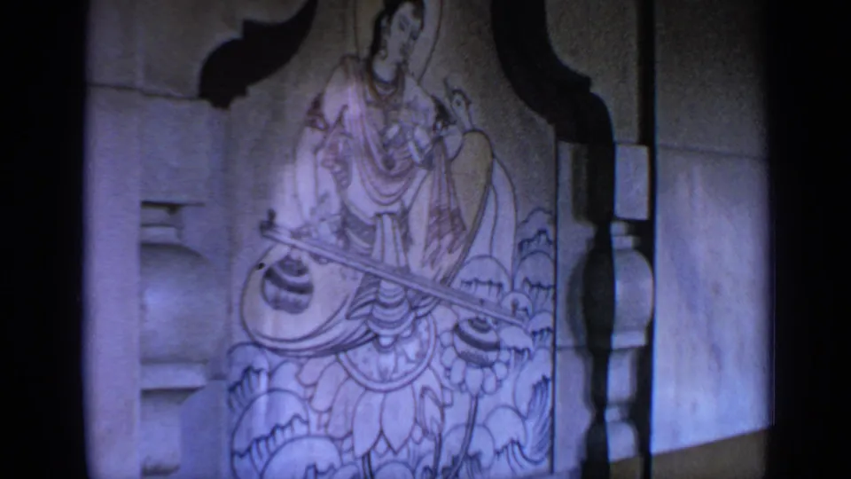 1970 India 8mm frame showing the same carved deity figure, softly focused and framed by the dark edge of the film scan.