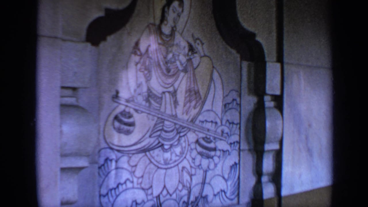 Wall painting of Saraswati seated on a lotus with a stringed instrument.