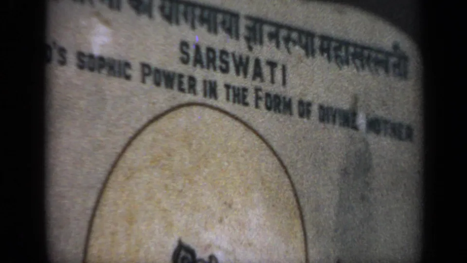 1970 India 8mm frame with a tight crop on the Saraswati sign and the phrase about divine mother partially visible.