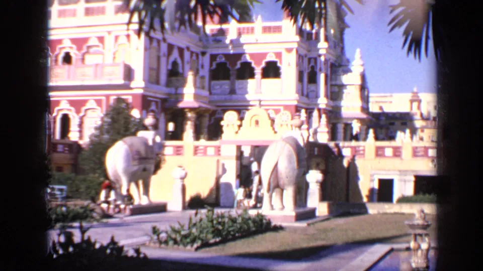 1970 India home-movie view of white elephant statues and a richly decorated palace-like facade in bright daylight.