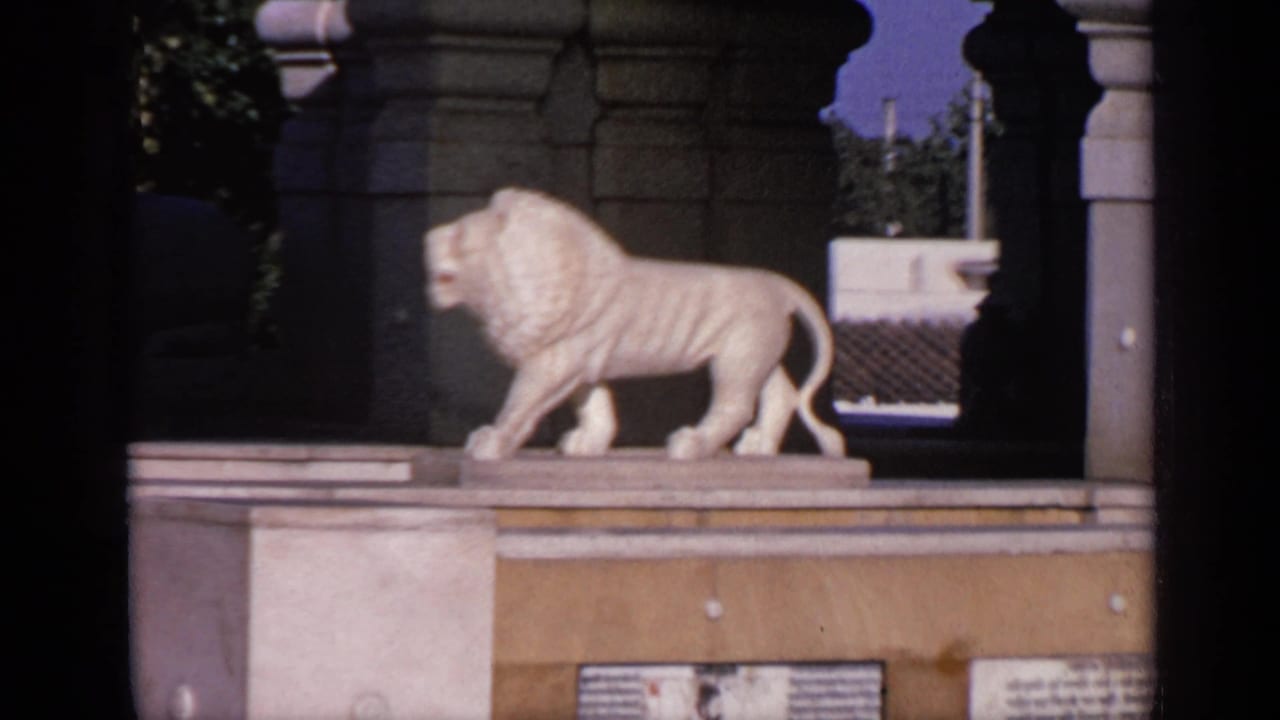 White lion statue on a pedestal beneath stone temple arches.