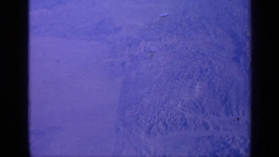 The final 8mm frame shifts to a blue-tinted, blurry exposure with no clear subject visible, likely from camera movement or film exposure variation.