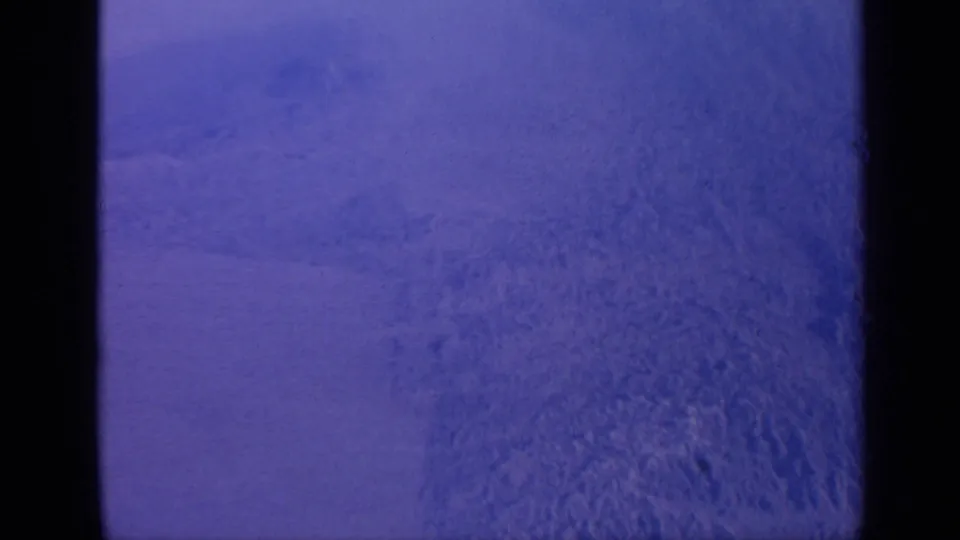 1970 India home-movie frame showing a static snow-covered mountain surface with purple-blue color cast and visible film gate edges.