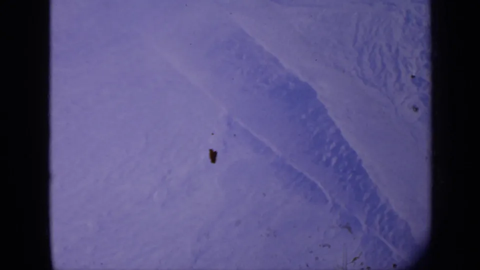 Final 1970 India frame showing snow-covered terrain, a shadowed ridge form, faded color, dust specks, and Super 8 gate edges.