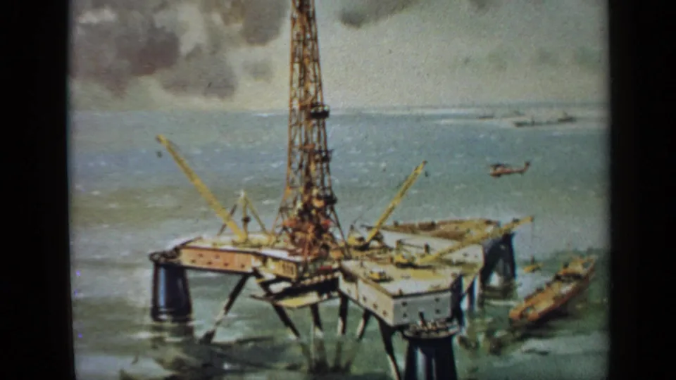 1970 United Kingdom 8mm frame of a filmed painting showing an offshore oil rig, cranes, a nearby boat and a distant helicopter.
