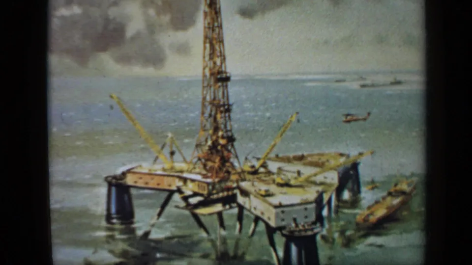 1970 United Kingdom 8mm frame showing a static filmed painting of an offshore oil rig with support craft and helicopter.